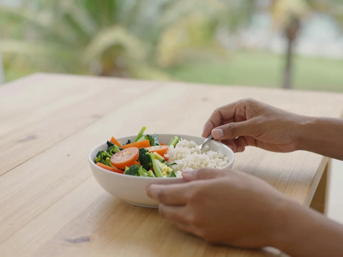 Editorial healthcare photography, soft tropical daylight: close-up of hands arranging a simple healthy lunch of vegetabl
